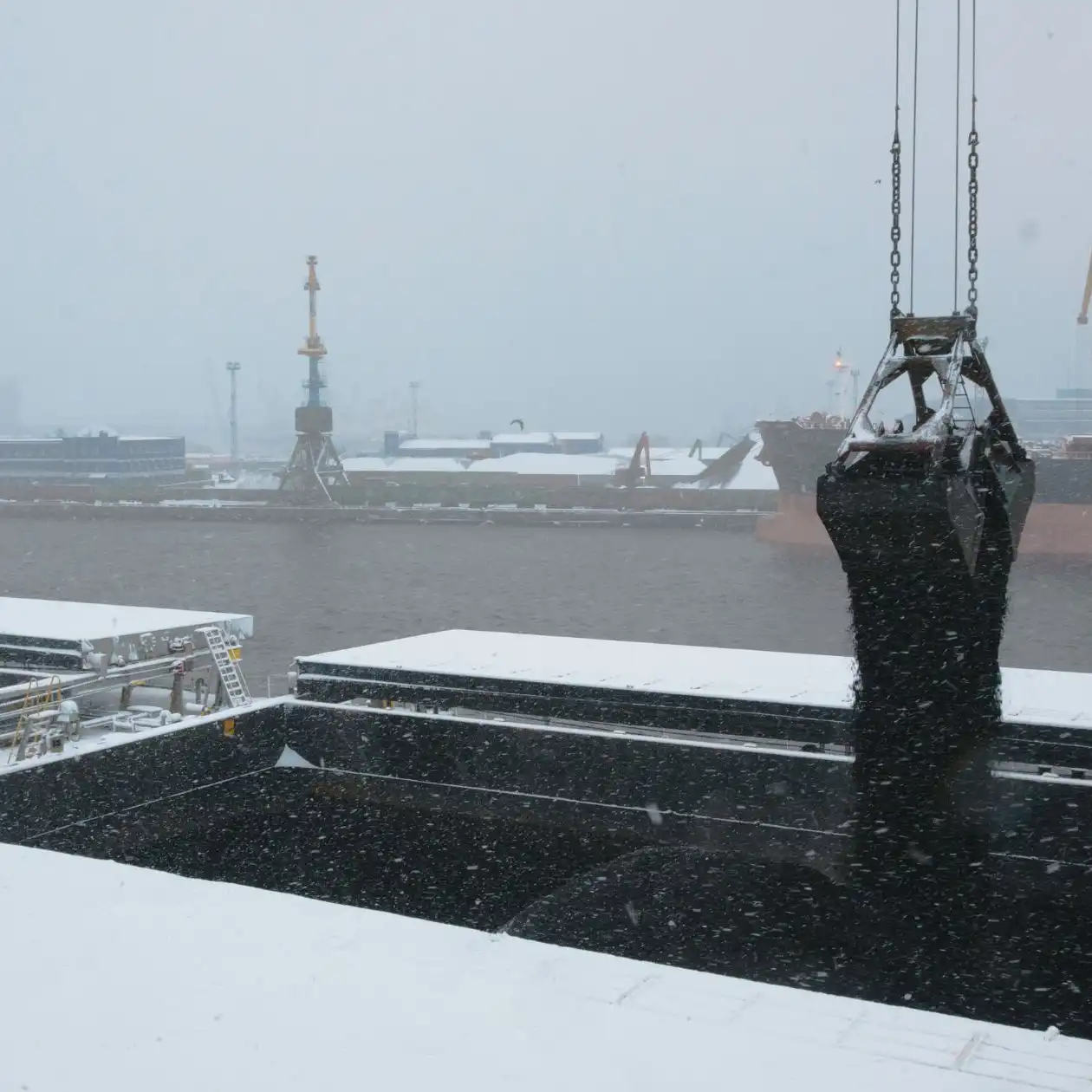 A mechanical grab depositing thermal coal into a bulk carrier's hold