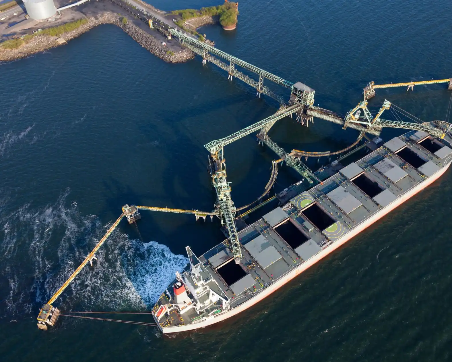 Aerial view of a bulk carrier at a terminal with shiploaders over its open holds
