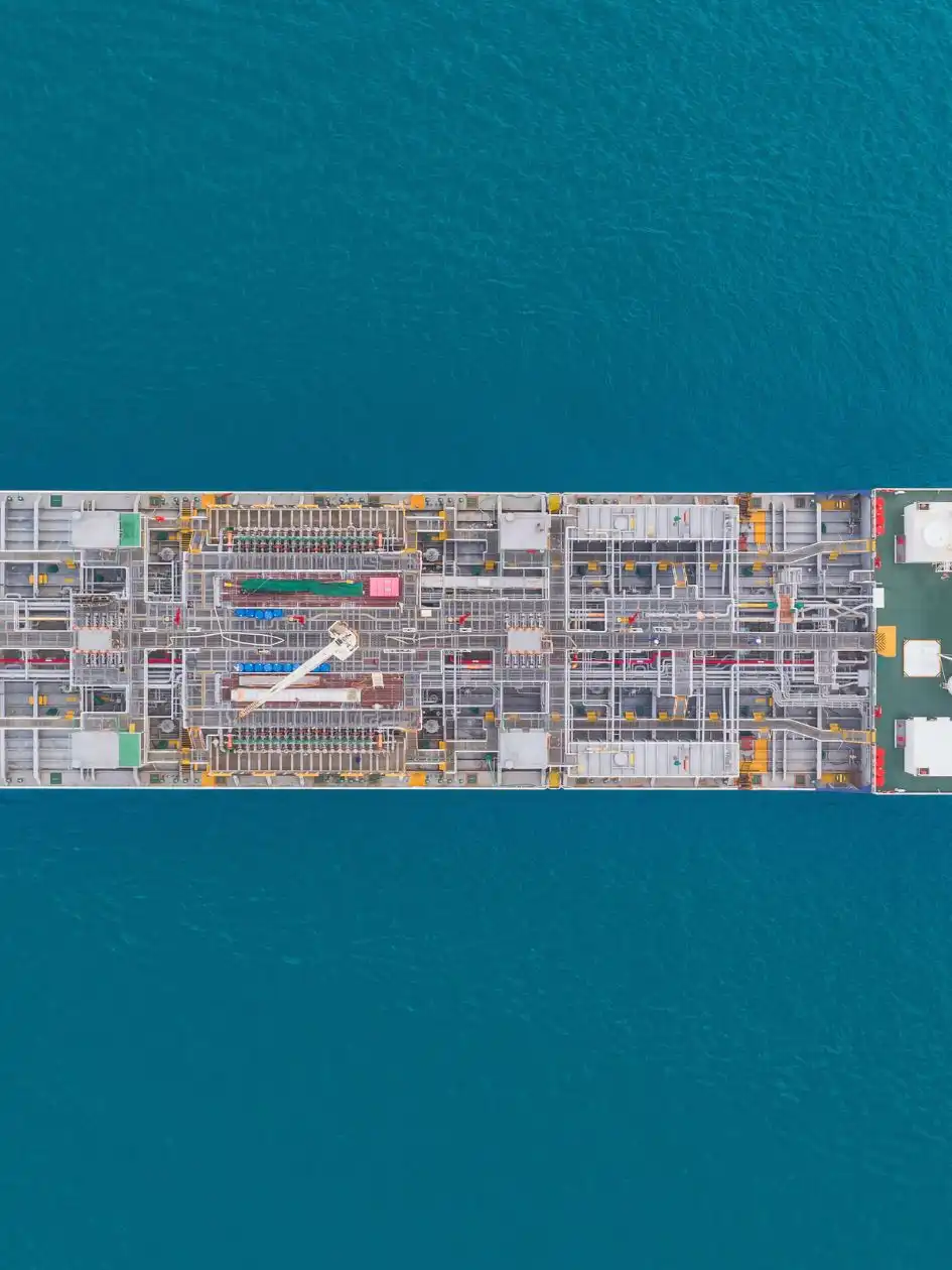 Aerial view of a products tanker underway in deep-blue water, deck pipework and equipment visible