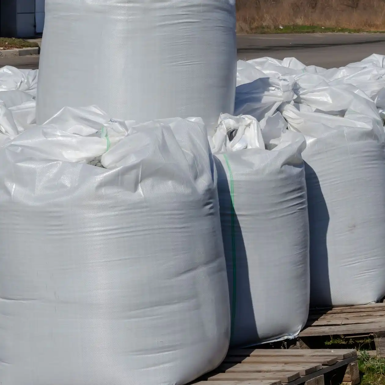 Large white bulk bags of product on pallets awaiting shipment