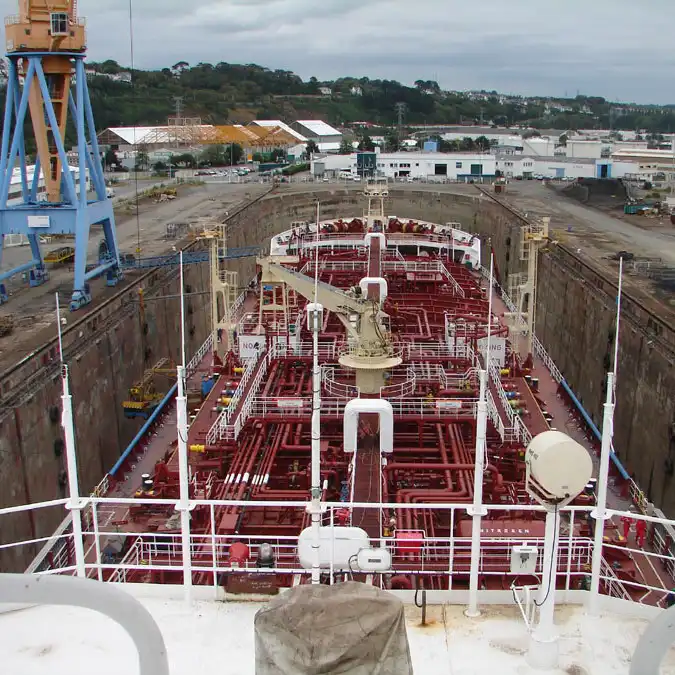 Looking down the deck of a product and chemical tanker, the full run of red cargo manifold piping and the central catwalk visible